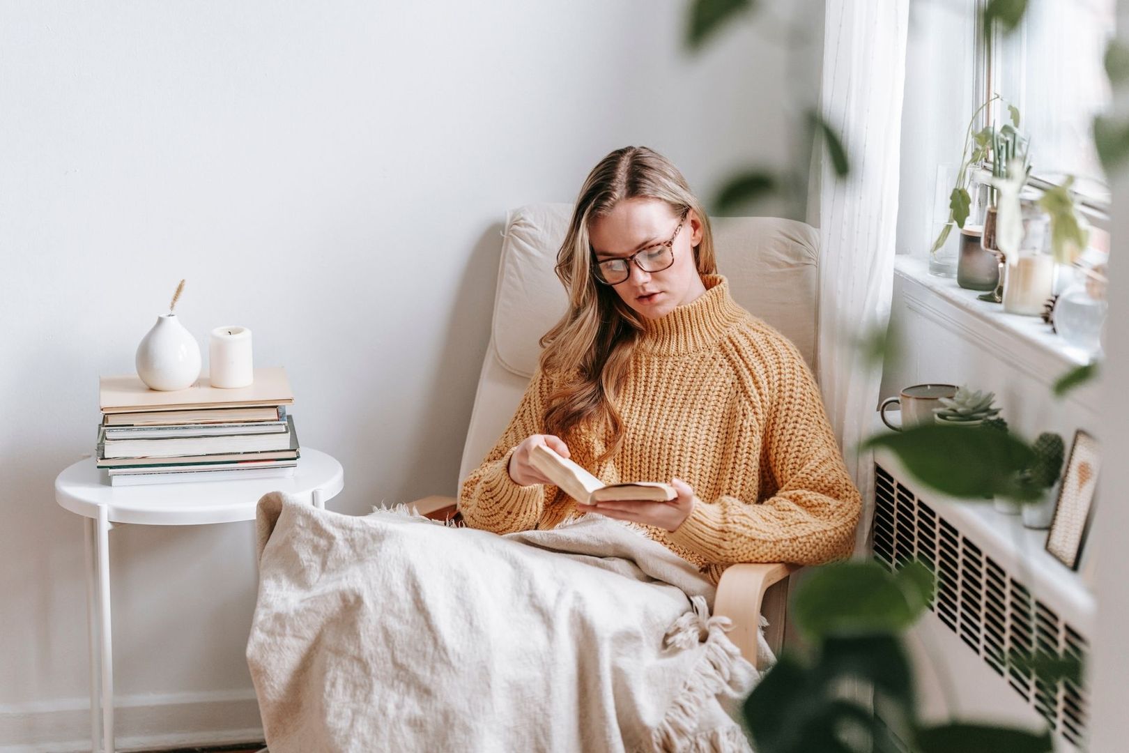 Woman in a cozy chair reading a book during a quiet indoor break
